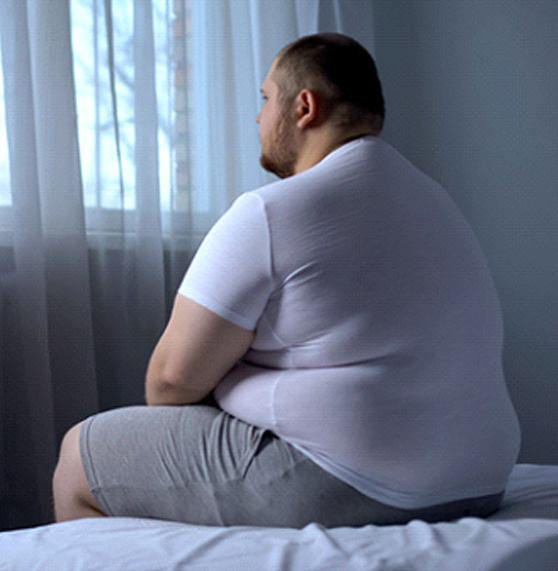 Overweight man sitting in bed