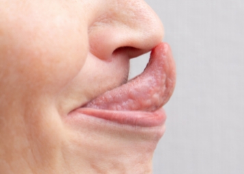 Close up of person touching their nose with their tongue