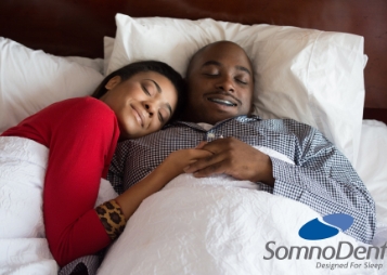 Couple smiling and cuddling while sleeping 