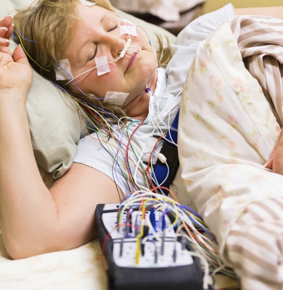 Sleeping woman hooked up to electrodes for sleep apnea testing