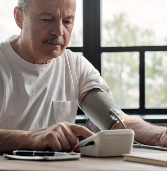 Senior man using an at home blood pressure monitor