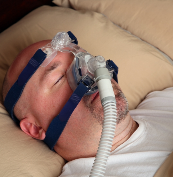 Man sleeping on his back with a C P A P mask on his face