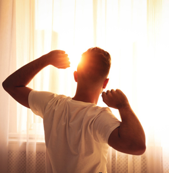 Man stretching after restful night of sleep